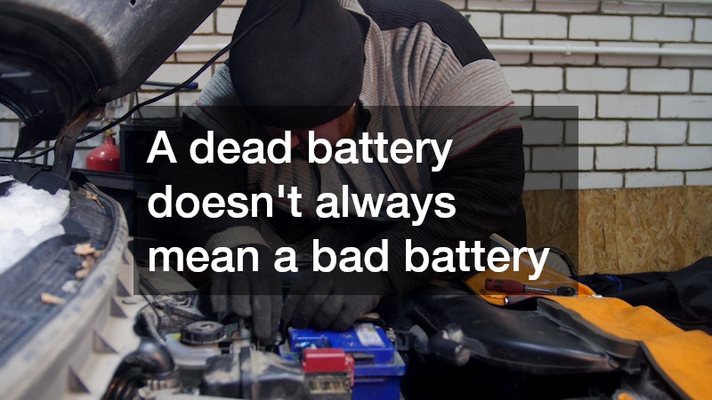 man fixing a car under an open hood